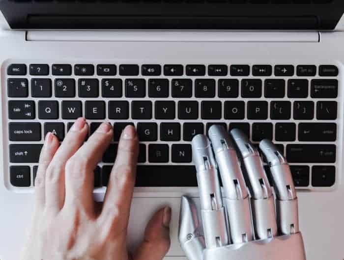 Robot hands and fingers point to laptop button advisor chatbot robotic artificial intelligence concept