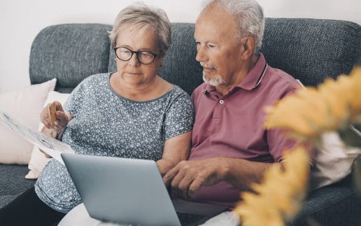 One Old Senior Couple At Home Paying Bills Online With Web Banki