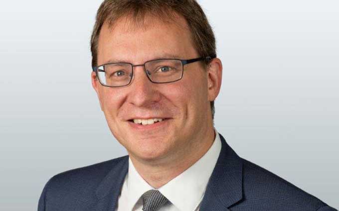 Das Bild zeigt Christian Brunner, Abteilungsleiter Cloud-Native bei FI-TS. Er trägt einen Anzug und eine Krawatte und hat eine freundliche Miene. Brunner ist seit fast 30 Jahren in der IT-Branche tätig und hat einen Abschluss als Diplom-Ingenieur in Elektro- und Informationstechnik. In seiner Funktion setzt er sich mit der Entwicklung und Implementierung von Cloud-Native-Lösungen auseinander, um die Bare-Metal-Cloud von FI-TS