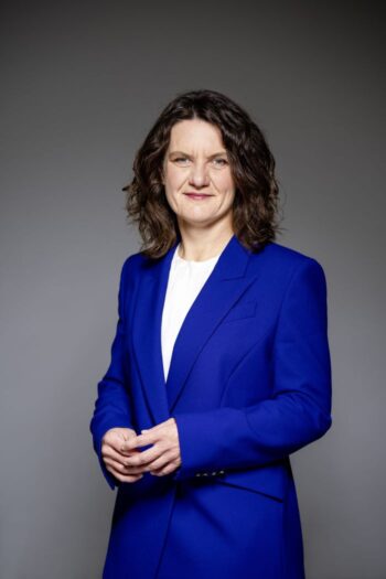 Kristin Seyboth, Vorstandsmitglied der Bausparkasse Schwäbisch Hall, präsentiert sich in einem blauen Blazer vor neutralem Hintergrund. Die Bausparkasse verfolgt im Bereich Innovationsmanagement einen vielschichtigen Ansatz, der ein eigenes Innovations-Lab sowie weitere Initiativen umfasst, um eine dynamische Innovationskultur zu fördern.