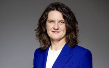 Das Bild zeigt Kristin Seyboth, Vorstandsmitglied der Bausparkasse Schwäbisch Hall und Mitglied der Geschäftsführung von Schwäbisch Hall Kreditservice. Sie trägt einen blauen Blazer und hat lockiges, braunes Haar. Ihre Mimik vermittelt Selbstbewusstsein. In ihrer Funktion verantwortet sie das Prozessmanagement, IT, Einkauf und Lieferantenmanagement, was im Rahmen des Innovationsmanagements von Bedeutung ist. Der Hintergrund ist neutral und unauffällig gestaltet.