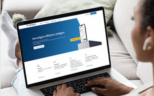 Auf dem Bild ist eine Person zu sehen, die auf einem Laptop arbeitet. Der Laptop zeigt eine Webseite mit dem Titel „Vermögen effizient anlegen“. Die Person sitzt auf einem hellen Sofa, trägt Kopfhörer und hat die Füße auf dem Sofa abgestellt. Im Hintergrund sind weitere Sofakissen zu erkennen. Die Umgebung wirkt gemütlich und einladend. Der Fokus liegt auf der Nutzung des Laptops, während die Person mit einem modernen Interface zur Geldanlage interagiert.