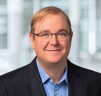 Das Bild zeigt Knut Besold, Partner bei KPMG. Er trägt ein dunkles Sakko und ein hellblaues Hemd. Der Hintergrund ist unscharf und deutet auf eine moderne Büroumgebung hin. In Anbetracht der aktuellen Trilog-Verhandlungen zur FiDA-Verordnung ist die Diskussion über Open Finance und die damit verbundenen technischen Herausforderungen von großer Bedeutung. Besolds Ausdruck vermittelt Professionalität und Engagement in der Thematik.