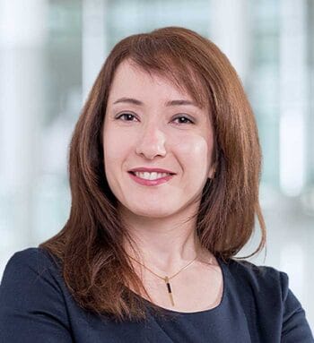 Das Bild zeigt Dr. Tirazheh Zare Garizy, Senior Managerin bei KPMG. Sie präsentiert sich mit einem neutralen Ausdruck und trägt ein dunkelblaues Oberteil. Der Hintergrund ist unscharf und vermittelt einen modernen, professionellen Eindruck. Im Kontext der Diskussion über Open Finance und die Herausforderungen der EU-Verordnung FiDA wird ihre Expertise in der Finanzbranche hervorgehoben.