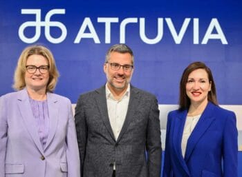 Das Bild zeigt das neue Vorstandsteam von Atruvia, bestehend aus drei Personen, die vor einem blauen Hintergrund mit dem Atruvia-Logo posieren. Die Anwesenden tragen formelle Kleidung und präsentieren sich professionell.