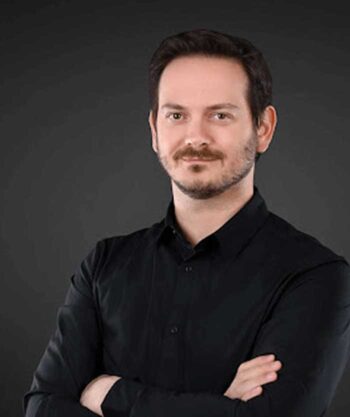 Giacomo Marinangeli, DSwiss, präsentiert sich in einem formellen, schwarzen Hemd. Seine Körperhaltung vermittelt Selbstbewusstsein und Professionalität. In der Diskussion um Cybersecurity sind Fehlkonfigurationen ein zentrales Thema, das besondere Aufmerksamkeit erfordert.
