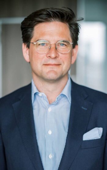 Peter Pohlschröder, Director Co-Head Digital Infrastructure bei Hauck Aufhäuser Lampe Privatbank, präsentiert sich in formeller Kleidung. Seine Expertise in Rechenzentren unterstreicht die Bedeutung von On-premise Lösungen für Banken.