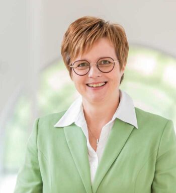 Manuela Moog, neue IT-Vorständin der DEVK, lächelt in einem hellgrünen Blazer. Ihr professionelles Auftreten unterstreicht ihre Rolle als Führungskraft im IT-Bereich des Unternehmens, das sie ab dem 1. November 2025 leiten