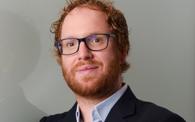 David Freund, Partner und Principal Consultant bei Senacor Technologies, präsentiert sich in einem professionellen Umfeld. Seine Expertise umfasst die Optimierung von Prozessen, insbesondere im Bereich Onboarding.