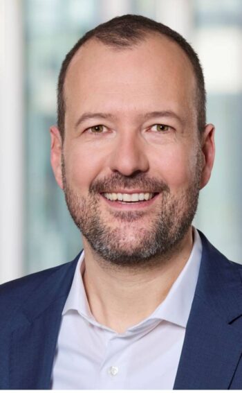 Dr. Philipp Wagner, Leiter Digitale Assets bei der Deutschen WertpapierService Bank, präsentiert sich in einem professionellen Umfeld. Seine Expertise im Bereich On-Chain Transaktionen unterstreicht die Bedeutung digitaler Technologien im Kapitalmarkt.