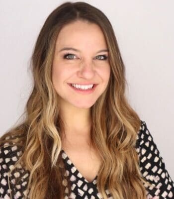 Amy Stout, Expertin im Bereich Künstliche Intelligenz, präsentiert sich mit einem freundlichen Lächeln. Ihr Hintergrund und die Kleidung deuten auf eine professionelle Umgebung hin. Im Kontext der Diskussion über Quanten-KI könnte sie relevante Einblicke bieten.