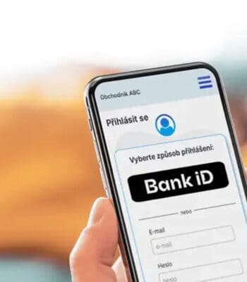 Ein Smartphone zeigt eine Anmeldeseite mit der Option „Bank iD“ zur Auswahl. Die Benutzeroberfläche ist in tschechischer Sprache gehalten und bietet Eingabefelder für E-Mail und Passwort. Digitale Identitäten werden durch diese Funktionalität unterstützt.