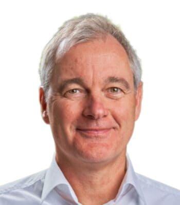 Peter Buhrmann, neuer CEO von GFT Deutschland, wird in einem professionellen Porträt abgebildet. Er trägt ein helles Hemd und präsentiert ein freundliches Lächeln. Der Hintergrund ist neutral gehalten, was den Fokus auf seine Person lenkt.