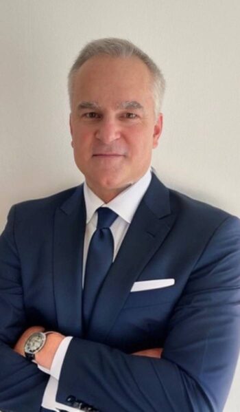 Arnd Gille, Director Solutions Consulting bei Palo Alto Networks, präsentiert sich in formeller Kleidung. Die Thematik der KI-Agenten wird im Kontext der Cybersicherheit und Identitätssicherung in der Finanzbranche behandelt.