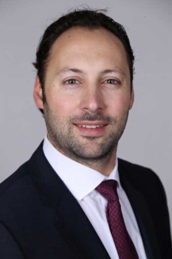 Florian Lauck-Wunderlich, Technical Solutions Director bei Pegasystems, präsentiert Konzepte zur Zusammenarbeit von KI-Agenten im Bankensektor. Diese Agenten sind darauf ausgelegt, komplexe Aufgaben effizient zu bewältigen, benötigen jedoch klare Regeln und Grenzen.