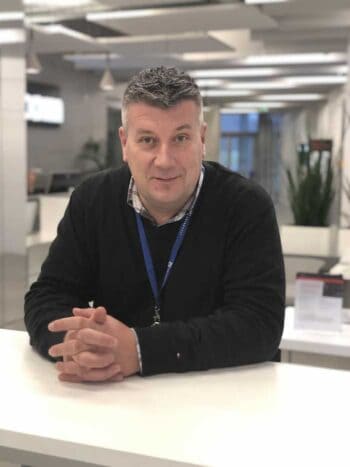 Lovro Persen, Director Document Management & Fraud bei IDnow, sitzt an einem Tisch in einem modernen Büro. Der Digital Services Act (DSA) wird als unzureichend erachtet, um Verbraucher effektiv vor Finanzbetrug zu schützen.