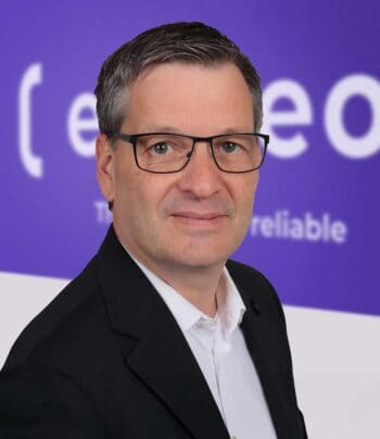 Bjoern Eckmayer, Sales Director bei Expleo, präsentiert sich vor einem lila Hintergrund. Die Governance im Softwareentwicklungsprozess wird durch kontinuierliche Prüfungen und Audit-Trails optimiert, um Abweichungen frühzeitig zu erkennen.