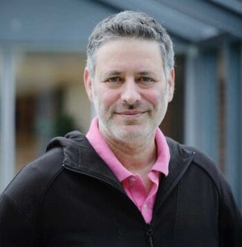 Niv Liran, CPTO von Unzer, präsentiert den internen KI-Assistenten UnzerAI. Dieser agiert als Agenten-System, das tief in Datenbanken integriert ist und zuverlässige Informationen bereitstellt, einschließlich Quellenlinks.