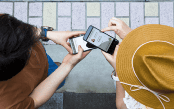 PSA Beitragsbild zeigt zwei Menschen mit Smartphones aus der Vogelperspektive.