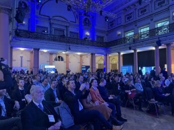 Die Veranstaltung Frankfurt Digital Finance versammelt ein internationales Publikum im Frankfurter Palmengarten. Über 50 Sessions und Keynotes sind im Gange, während die Teilnehmer aufmerksam den Präsentationen folgen.