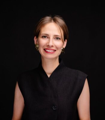 Die frühere stellvertretende Digitalministerin der Ukraine hat eine neue Position bei IDnow übernommen. Sie trägt ein schwarzes, ärmelloses Oberteil und präsentiert sich mit einem freundlichen Lächeln vor einem dunklen Hintergrund.