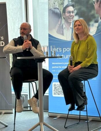 Zwei Personen diskutieren auf einer Bühne während des International Bankers Forum. Im Hintergrund ist ein Banner von Wavestone zu sehen. Die Veranstaltung fokussiert sich auf den Einsatz von KI in Banken und die Rolle von Agenten in der Transformation.