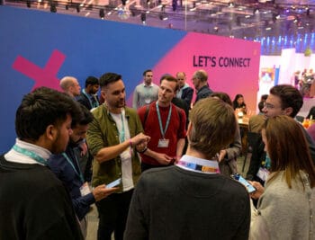 Im Rahmen der FIBE 2026 diskutieren Fachleute aus der Finanz- und Tech-Branche in einer Gruppeninteraktion. Die Veranstaltung fördert den Austausch und das Networking unter den Teilnehmenden. Hintergrund mit der Aufschrift „LET'S CONNECT“ ist sichtbar.