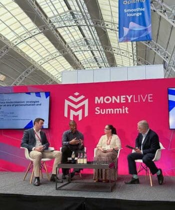 Auf der MoneyLive 2026-Bühne diskutieren vier Experten über Strategien zur Datenmodernisierung. Im Hintergrund ist die Konferenzdekoration sichtbar, die das Event hervorhebt. Die Atmosphäre ist professionell und fokussiert auf Innovation im Bankensektor.