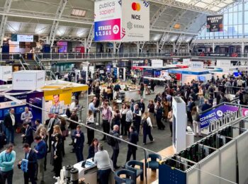 Die Veranstaltung MoneyLive 2026 zeigt eine belebte Messehalle mit zahlreichen Ständen und Besuchern. Unternehmen präsentieren ihre Lösungen, während Fachleute in Gespräche vertieft sind. Der Fokus liegt auf Innovationen im Bankensektor und Life-Event-Banking.