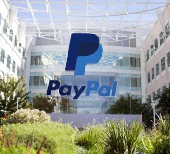 Das Bild zeigt das PayPal Hauptquartier mit dem markanten Logo des Unternehmens im Vordergrund. Die moderne Architektur und die umgebende Vegetation vermitteln einen Eindruck von Innovation und Technologie im Bereich digitaler Zahlungsverkehr.