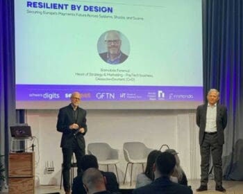 Barnabás Ferenczi, Head of Strategy & Marketing bei Giesecke+Devrient, präsentiert das Thema „Resilient by Design“ zur Sicherung der europäischen Zahlungsinfrastruktur. Im Hintergrund sind weitere Teilnehmer und eine Präsentation zu sehen.