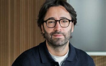 Okay Güler, Gründer und CEO von CLOUDYRION, wird in einem professionellen Umfeld abgebildet. Seine Expertise in Sicherheitsarchitekturen ist besonders relevant im Kontext der NIS2-Richtlinie, die die Cybersicherheit in der Finanzbranche stärkt.