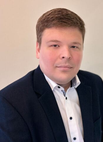 Sebastian Freimann, Product Owner bei Finanz Informatik, präsentiert sich in einem formellen Outfit. Im Kontext des Projekts zur Entwicklung eines IT-Ökosystems für die Immobilienbranche spielt er eine zentrale Rolle.