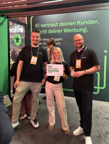 Auf dem OMR-Festival 2026 präsentieren Mitarbeiter von Trustpilot ihre Dienstleistungen. Eine Person hält ein Schild mit der Bewertung „5,0 Hervorragend“. Die Veranstaltung betont die Bedeutung von User Generated Content für Banken.