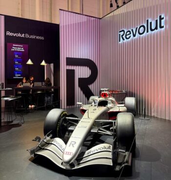 Der Audi Formel-1-Wagen, präsentiert von Revolut, steht prominent am Stand der Neobank auf dem OMR-Festival 2026. Im Hintergrund sind Mitarbeiter an Computern zu sehen, die Informationen bereitstellen.