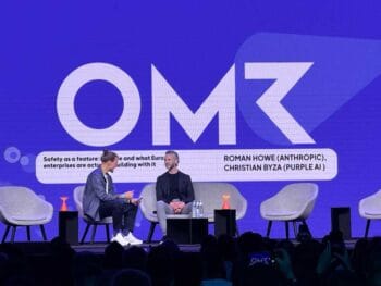 Roman Howe von Anthropic und Christian Byza von Purple AI diskutieren auf der OMR-Bühne über Sicherheit als Merkmal in europäischen Unternehmen. Die Veranstaltung zieht ein interessiertes Publikum an und fördert den Austausch über aktuelle Themen.