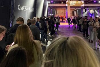 Lange Warteschlangen prägen das OMR-Festival 2026 Masterclasses. Teilnehmer stehen vor den Eingängen, während im Hintergrund ein dichtes Programm und zahlreiche Formate auf die Besucher warten. Die Atmosphäre ist geprägt von regem Interesse und hoher Teilnehmerzahl.