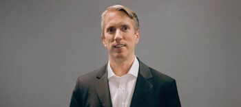 Johannes Neander, Co-Founder der Arlegon Management Consulting, präsentiert sich in formeller Kleidung. Seine Expertise umfasst die Entwicklung profitabler Kreditkartenprogramme und digitale Transformation im Finanzsektor.