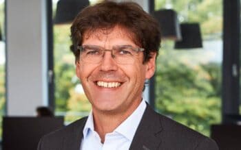 Stefan Schmid, Geschäftsführer bei Sopra Steria Custom Software Solutions, präsentiert sich in einem modernen Büro. Der Fokus liegt auf seiner Rolle in der Cloud-Architektur und der Umsetzung von IT-Transformationsprogrammen in regulierten Branchen.