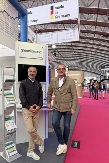Auf der Veranstaltung Money20/20 stehen zwei Personen am Stand von GreenBanana. Marcus W. Mosen, ein europäischer FinTech-Enthusiast, ist als Investor und Beirat aktiv. Der Stand hebt die Innovationskraft im BNPL-Sektor hervor.