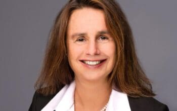 Claudia Grüber, Partnerin der PPI, präsentiert sich mit einem professionellen Lächeln. Ihre über 30-jährige Erfahrung in der Versicherungsbranche macht sie zur Expertin für digitale Transformation und die Modernisierung von Kernsystemen.