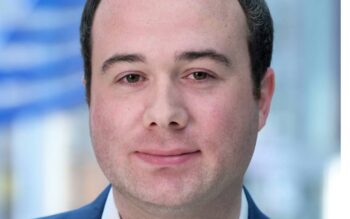 David Kleinewegen, Bereich Kapitalmärkte der NRW.BANK, wird in einem professionellen Umfeld abgebildet. Die Zusammenarbeit verschiedener Marktteilnehmer wird als entscheidender Erfolgsfaktor für innovative Transaktionen hervorgehoben.