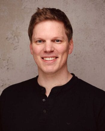 Johannes Meyer, Senior Market Development Manager (Cloud) bei noris network, präsentiert sich lächelnd vor einem neutralen Hintergrund. Seine Rolle ist entscheidend für die Entwicklung von KI-Strategien, insbesondere für Finanzdienstleister, die in die Cloud migrieren möchten.