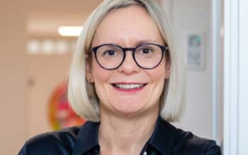 Sandra Dury, Rechtsanwältin und Geschäftsführerin von Dury Consult, präsentiert sich in einem professionellen Umfeld. Sie trägt ein schwarzes Oberteil und hat blonden, schulterlangen Haar. Ihr Lächeln vermittelt Offenheit und Kompetenz im Bereich Datenschutz.