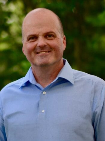 Stefan Hirschberg, Solution Engineer bei Datadobi, wird in einem informellen Umfeld abgebildet. Der Fokus liegt auf unstrukturierte Daten und deren Herausforderungen in Bezug auf Wiederherstellbarkeit, Berechtigungen und Compliance in der Banken- und Versicherungsbranche.