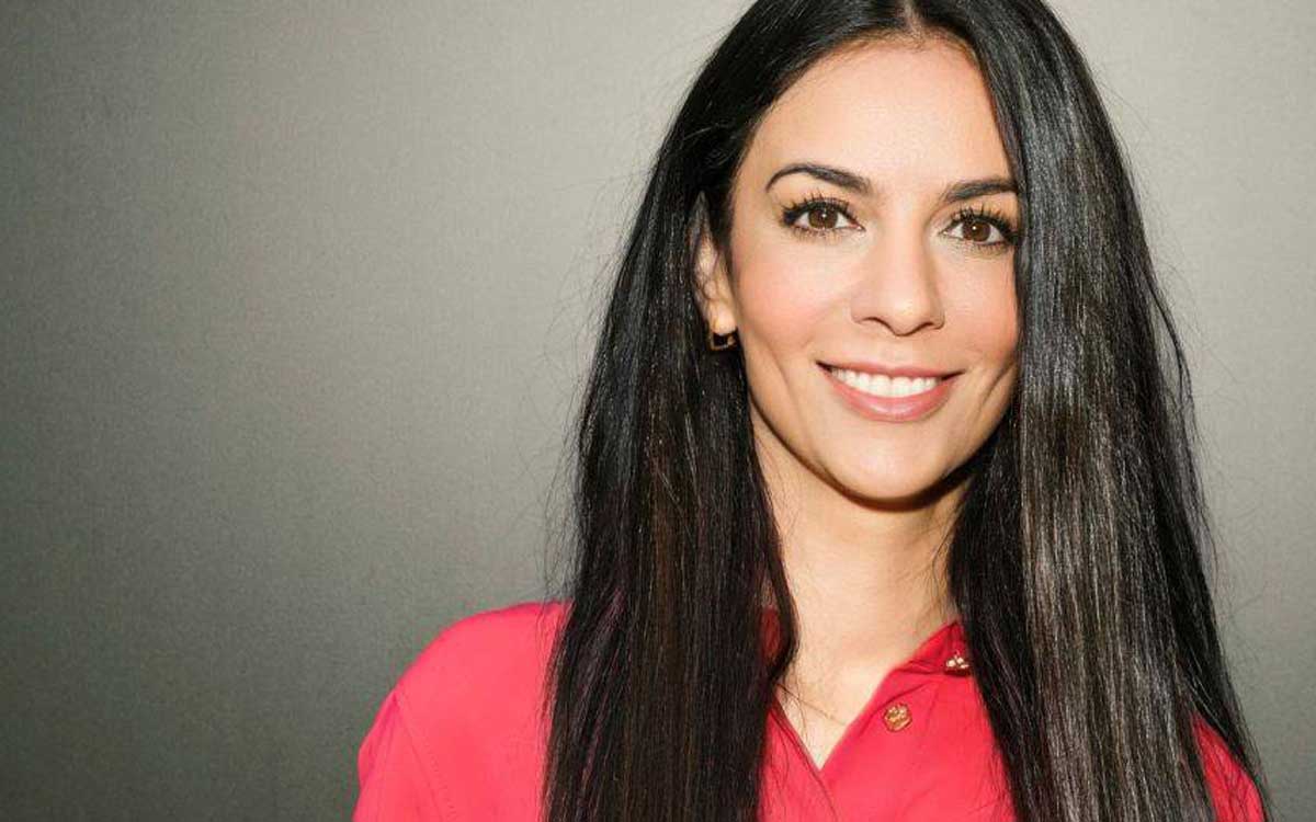 Dr. Samareh Frantz, Geschäftsführerin von epay, präsentiert sich in einem professionellen Porträt. Sie trägt ein rotes Oberteil und hat lange, schwarze Haare. Der Hintergrund ist neutral gehalten, was den Fokus auf ihre Person lenkt.