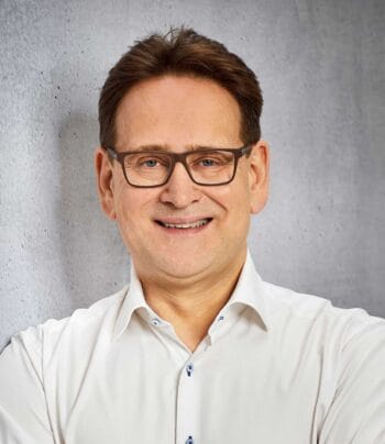 Dr. Markus von Detten, Senior Consultant PKI bei achelos, präsentiert sich mit einem freundlichen Lächeln vor einem neutralen Hintergrund. Die Anforderungen der DORA-Regulierung zur digitalen Resilienz sind ein zentrales Thema in seinem Fachgebiet.