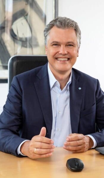 Dr. Herbert Schneidemann, Vorsitzender des Vorstands der Bayerischen, präsentiert sich in einem professionellen Umfeld. Die Thematik KYC und pKYC ist im Kontext der bevorstehenden EU-Geldwäscheverordnung von zentraler Bedeutung.