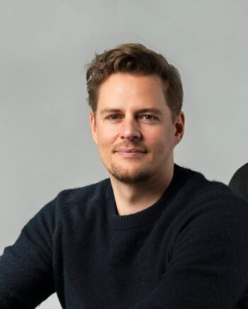 Martin Kassing, CEO und Mitgründer von Upvest, präsentiert sich in einem professionellen Umfeld. Seine Rolle ist entscheidend für die Kooperation mit Flinket, die innovative fondsgebundene Versicherungsprodukte in Spanien entwickelt.