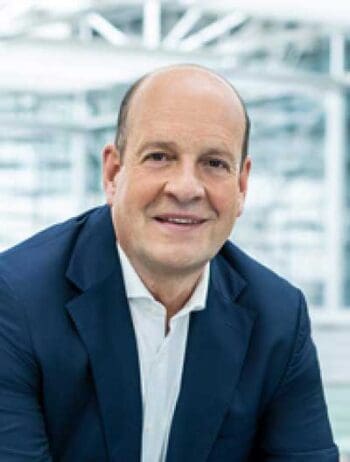 Dr. Jan-Henrik Andersson, Chief Commercial Officer (CCO) der Flughafen München, präsentiert sich in einem modernen Umfeld. Der Hintergrund deutet auf eine zeitgemäße Architektur hin, die den Innovationsgeist des Flughafens widerspiegelt.